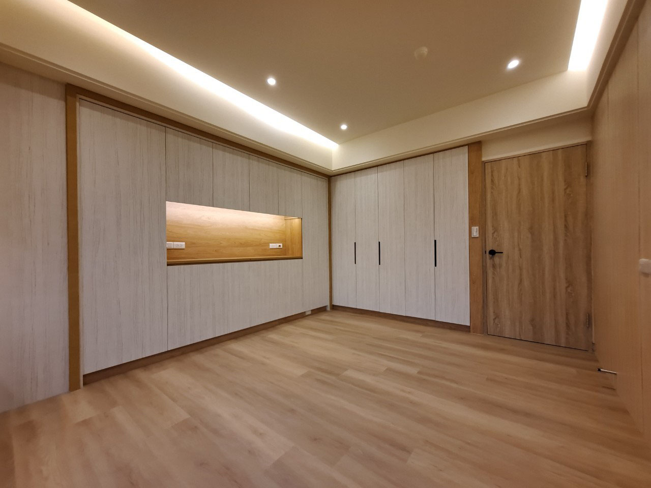 老屋翻新主臥室設計－木地板與整面衣櫃，搭配間接照明營造沉靜舒適氛圍。